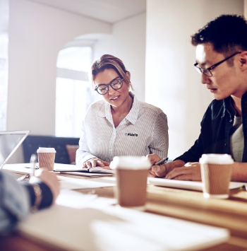 A businessman and a business woman working on some paperwork in an office